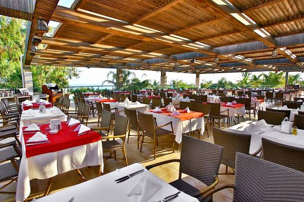 Terrassenrestaurant im Sunis Kumköy Beach Resort & Spa mit gedeckten Tischen und Stühlen.