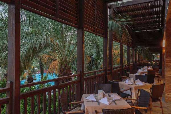 Terrasse des Sunis Kumköy Beach Resorts mit Blick auf einen Swimmingpool und Palmen