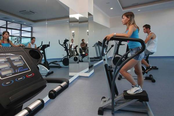 Mehrere Personen trainieren im Fitnessstudio auf verschiedenen Geräten.