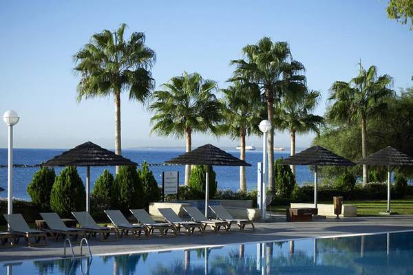 Außenpool des Atlantica Miramare Beach Hotel mit Sonnenliegen und Sonnenschirmen.