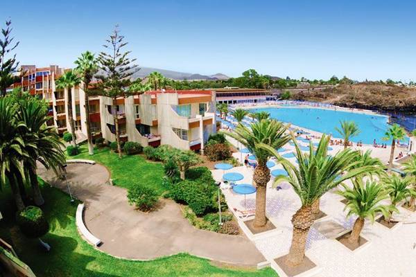 Luftaufnahme des Alborada Ocean Club Hotels mit großem Pool und tropischen Bäumen.