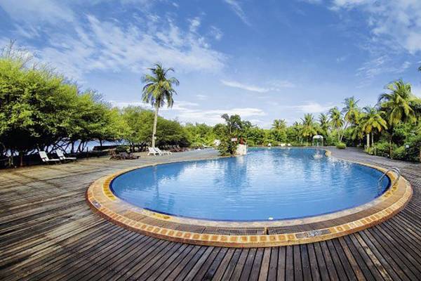 Außenpool des Cinnamon Dhonveli Maldives Hotels auf einem hölzernen Steg.