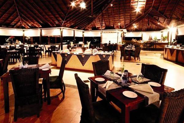 Innenbereich des Restaurants im Cinnamon Dhonveli Maldives mit gedeckten Tischen und Stühlen.