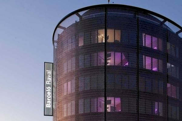 Barcelo Raval Hochhaus mit violetten Beleuchtung bei Nacht