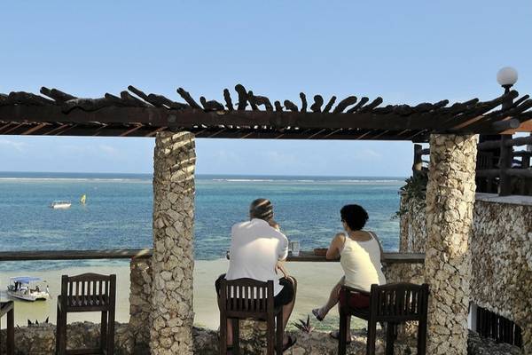 Zwei Personen sitzen an einer Bar im Bahari Beach Hotel mit Blick auf das Meer.