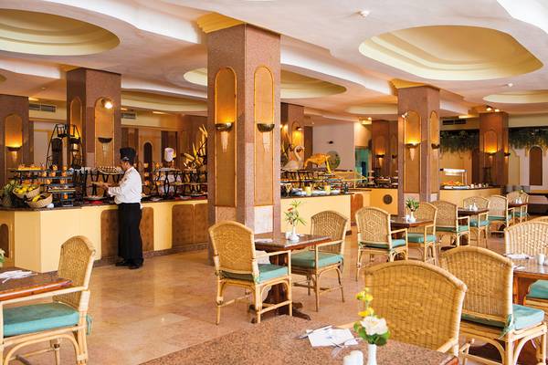 Ein Speisesaal im Grand Hotel Hurghada mit einem Buffet und einem Tisch.