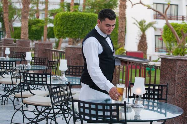 Ein Hotelmitarbeiter serviert ein Bier auf der Terrasse des Grand Hotel Hurghada.