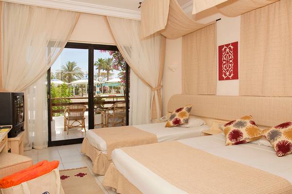Doppelzimmer im Grand Hotel Hurghada mit zwei Betten, Balkon und Blick auf die Außenterrasse.