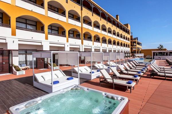 Außenbereich des Occidental Jandia Royal Level Hotels mit Sonnenliegen, Whirlpool und Loungebereich.