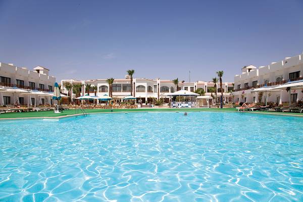 Außenpool des Grand Hotel Hurghada mit Sonnenliegen und Schirmen.
