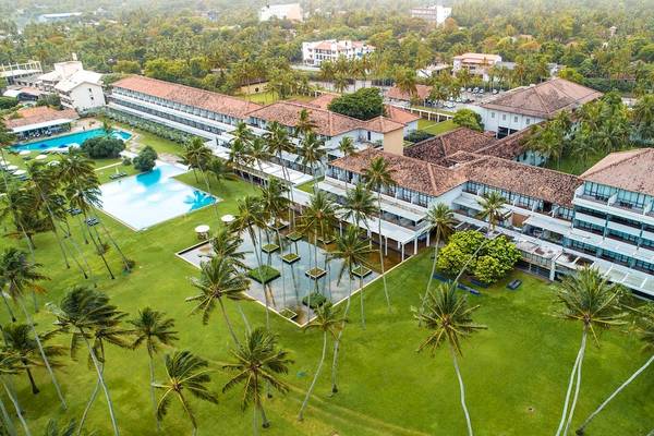 Luftaufnahme des Blue Water Hotel und Spa mit Swimmingpool und tropischen Bäumen