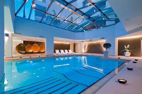 Innenpool des Porto Platanias Beach Resort & Spa mit Glasdach und Loungebereich