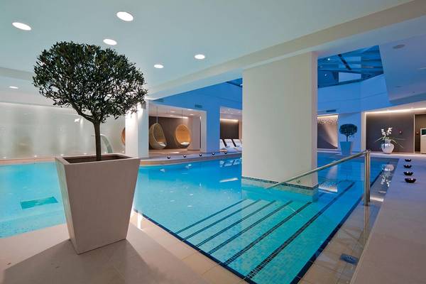 Innenpool des Porto Platanias Beach Resort & Spa mit blauem Wasser und weißen Fliesen