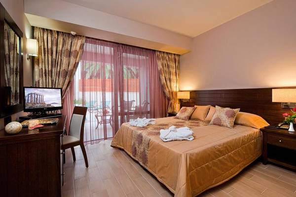 Hotelzimmer im Porto Platanias Beach Resort & Spa mit großem Bett, Schreibtisch und Aussicht.