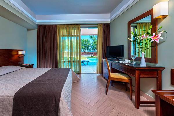 Doppelbettzimmer im Porto Platanias Beach Resort mit Zugang zur Terrasse und Swimmingpool.