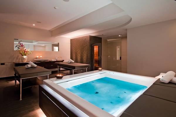 Spa-Bereich im Porto Platanias Beach Resort & Spa mit Whirlpool und Ruheliegen.