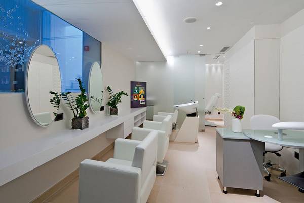 Friseursalon im Porto Platanias Beach Resort & Spa mit weißen Möbeln, Spiegeln und Pflanzen