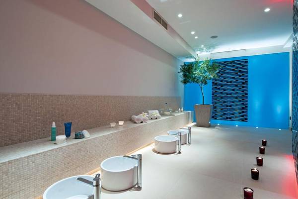 Spa-Bereich im Porto Platanias Beach Resort & Spa mit weißen Wannen und blauen Wänden.