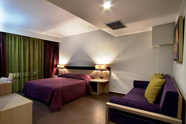 Hotelzimmer im Porto Platanias Beach Resort & Spa mit einem Bett und einer Couch.