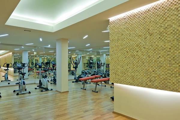 Fitness-Center im Porto Platanias Beach Resort & Spa mit vielen Geräten und Spiegeln.