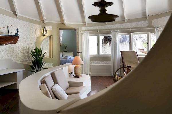 Wohnbereich im Nika Island Resort & Spa mit weißem Sofa, Tisch, Lampen und Pflanzen.