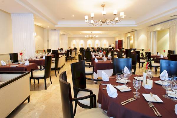 Innenansicht des Restaurants im Grand Sunset Princess All Suites Resort mit gedeckten Tischen und einer eleganten Atmosphäre.