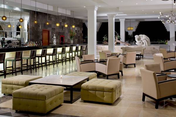 Loungebereich im Grand Sunset Princess All Suites Resort Hotel mit Bar, Sesseln und Tischen.