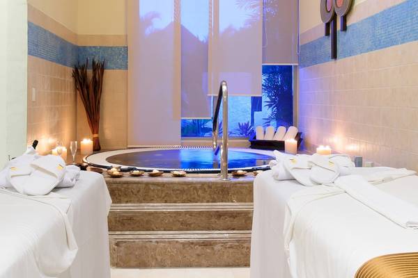 Spa-Bereich im Grand Sunset Princess All Suites Resort mit Whirlpool, Kerzen und Liegen.