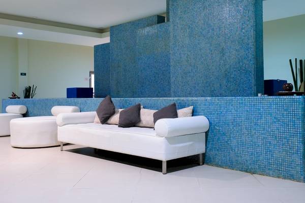 Lobby des Grand Sunset Princess All Suites Resorts mit blauen Fliesen und weißen Möbeln.
