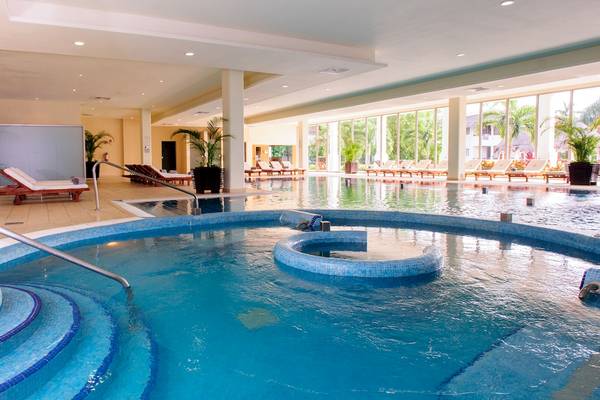 Außenpool des Grand Sunset Princess All Suites Resorts mit Loungeliegen und Pflanzen