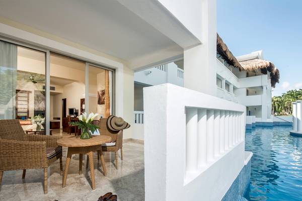 Terrasse des Grand Sunset Princess All Suites Resorts mit Tisch, Stühlen und Pool
