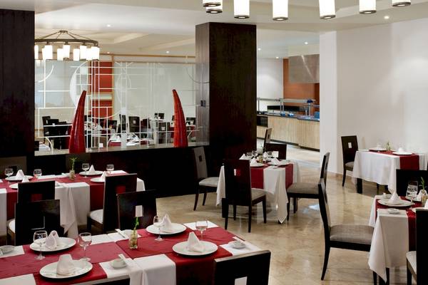 Innenansicht des Restaurants im Grand Sunset Princess All Suites Resort mit elegant gedeckten Tischen und Stühlen.