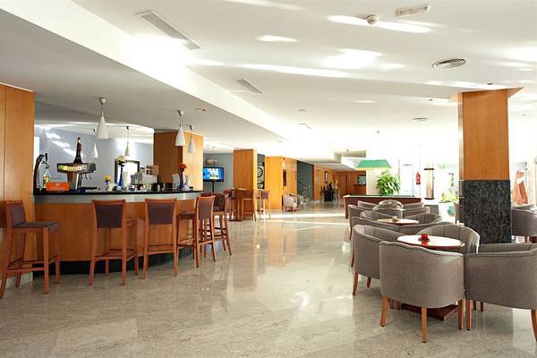 Barbereich im LIVVO Costa Taurito Hotel mit Holzstühlen und Tischen.