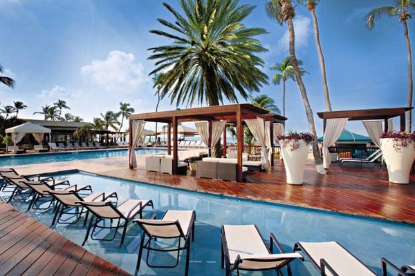 Außenpoolbereich mit Lounge-Bereich im Hotel Divi Tamarijn Aruba bei Sonnenschein