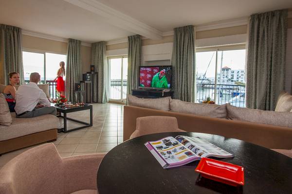 Hotel Wohnzimmer mit Fernseher, Sofas, Tisch und Aussicht auf den Hafen