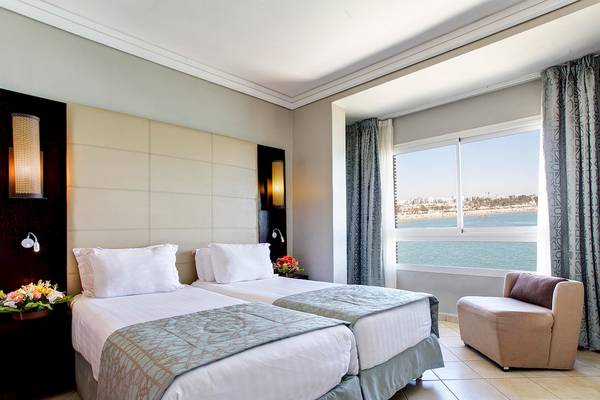 Zwei Betten in einem Zimmer im Bianca Beach Resort mit Blick auf das Meer.