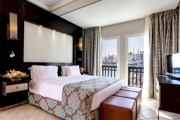 Innenansicht eines Hotelzimmers im Bianca Beach Resort mit Bett, Nachttischen, Fernseher und Balkon.