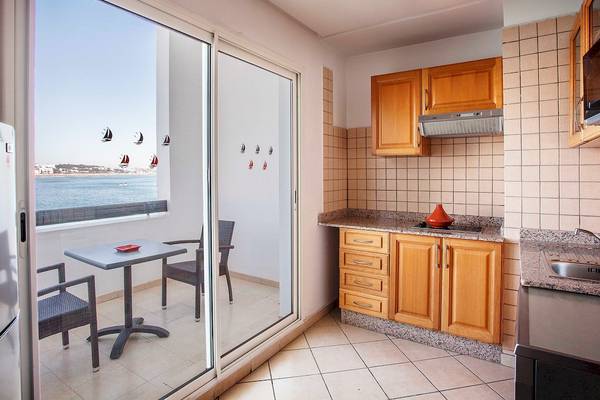 Küche im Bianca Beach Resort mit Blick auf das Meer und eine Terrasse mit Tisch und Stühlen.