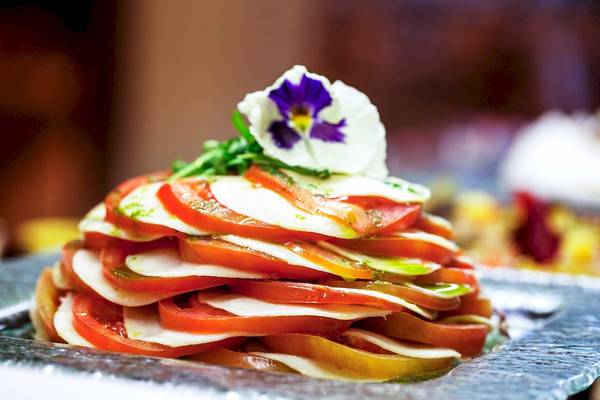 Eine Schicht von Tomaten und Mozzarella mit einer Blume garniert im Bianca Beach Resort.