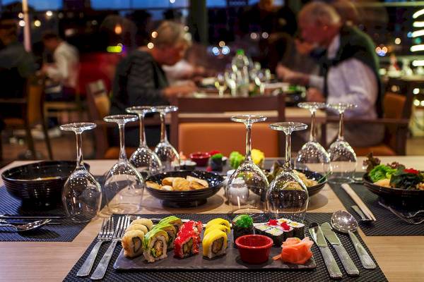 Restauranttisch im Bianca Beach Resort mit Sushi, Getränkegläsern und Geschirr.