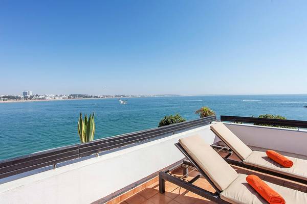 Blick vom Balkon des Bianca Beach Resorts auf das Meer mit einem fliegenden Vogel und einem Hotelgebäude im Hintergrund.