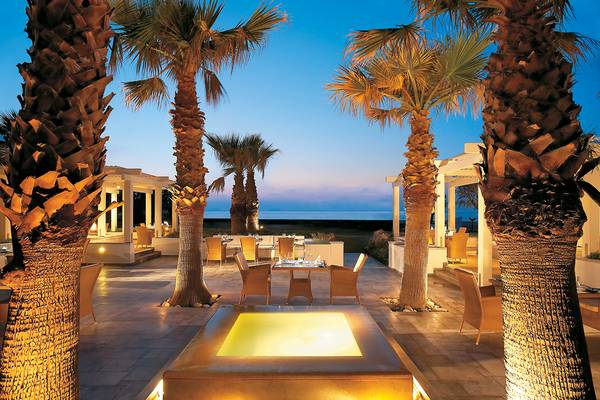 Abendessen unter Palmen im Grecotel Creta Palace mit Blick auf das Meer.