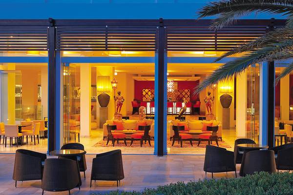 Außenbereich des Grecotel Creta Palace Hotels mit Loungemöbeln und Inneneinrichtung.