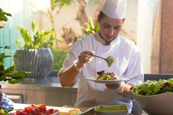Ein Koch im Grecotel Creta Palace serviert einen Salat