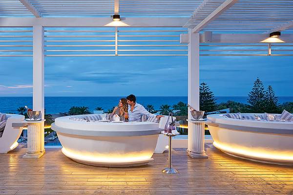 Paar genießt Blick auf Meer von Bar im Grecotel Creta Palace Resort