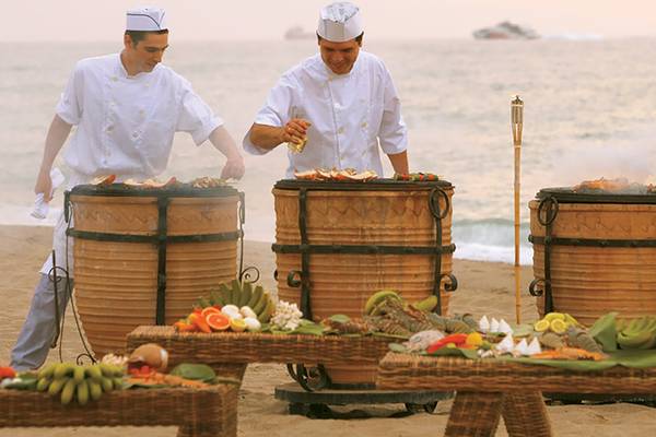 Zwei Köche bereiten am Strand ein Grillbuffet im Grecotel Creta Palace zu.