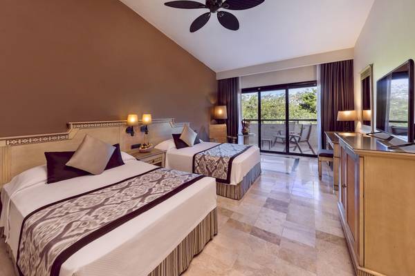 Suite-Zimmer im Grand Palladium Kantenah Resort mit zwei Betten, Balkon und moderner Einrichtung.