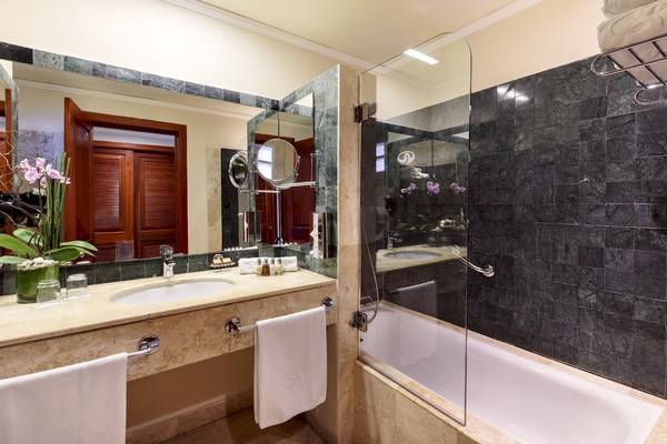 Ein Badezimmer im Grand Palladium Kantenah Resort & Spa mit Marmorboden und -wand, Badewanne und Dusche.