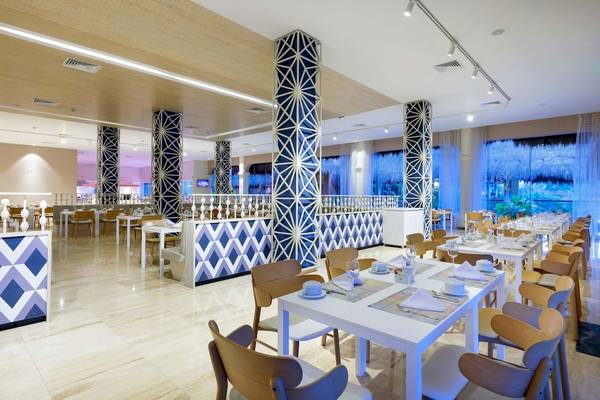 Restaurant im Grand Palladium Kantenah Resort & Spa mit blau-weißen Mustersäulen und geometrischen Mustern.
