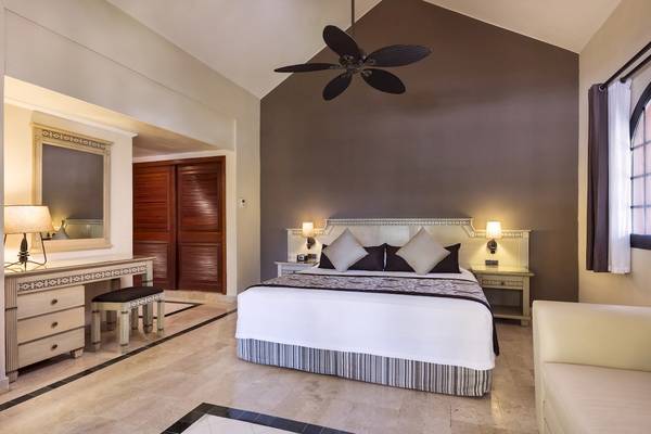 Schlafzimmer im Grand Palladium Kantenah Resort & Spa mit Bett, Nachttischen und Schreibtisch.